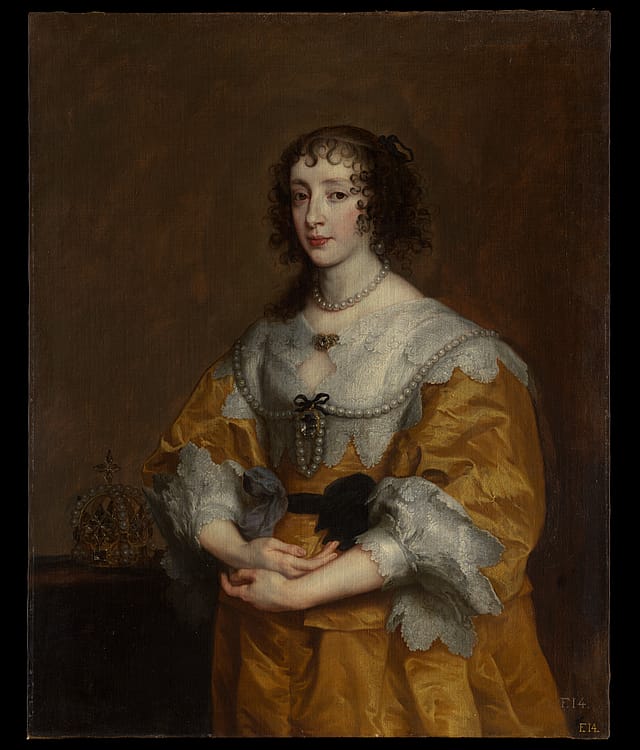 Half-portrait painting of a woman in front of a brown background. She is wearing an elaborate yellow dress with a white lace collar and sleeves. She has a pearl necklace and there is a black belt tied around her waist. To her immediate right, a crown sits on a small table.