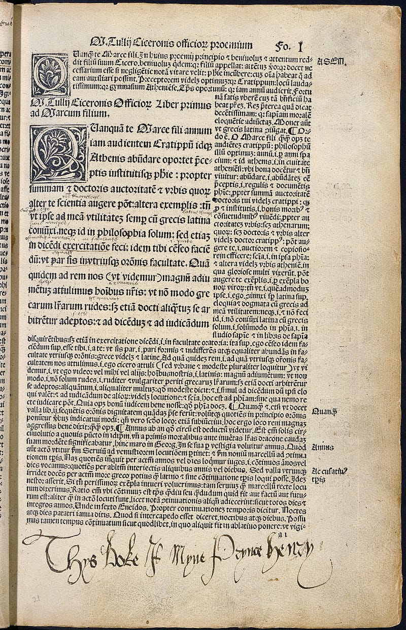 Page from an old book with gothic font. At the bottom of the book in the margin there is a note written in ink in elegant handwriting.