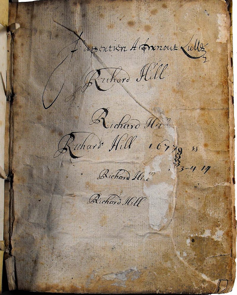 An old disoloured page from a book. It is stained and torn around the edges. The name 'Richard Hall' has been written five times on the page in cursive writing in black ink. One instance of the name is accompanied by the date '1677'.