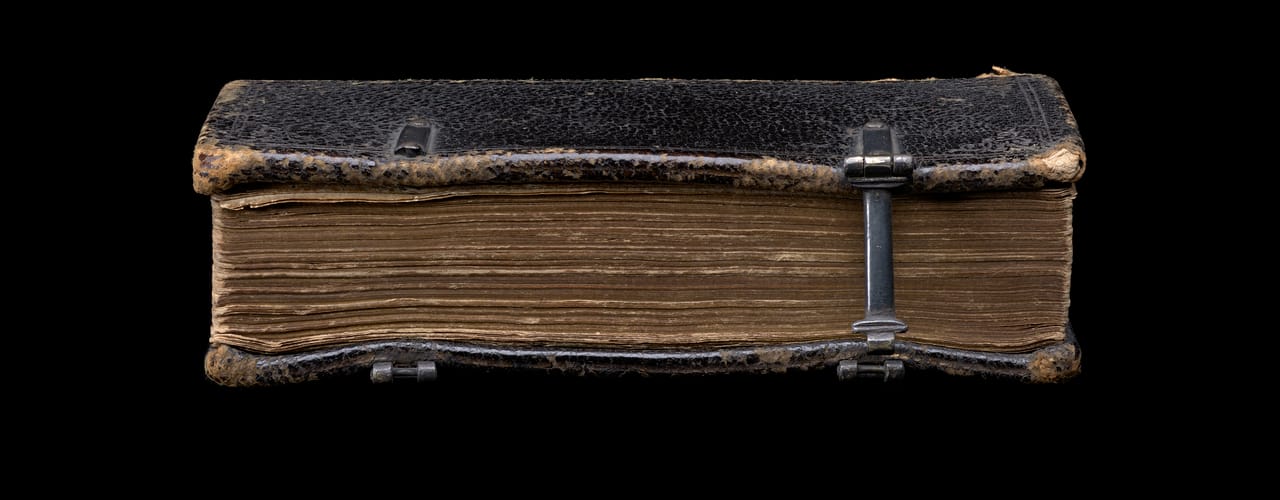 The fore-edge of a book, bound in worn black leather, held together with a clasp. Eikōn basilikē : the pourtraicture of His Sacred Majestie in his solitudes and sufferings (1649).  SLV Emmerson Collection RAREEMM 115/27