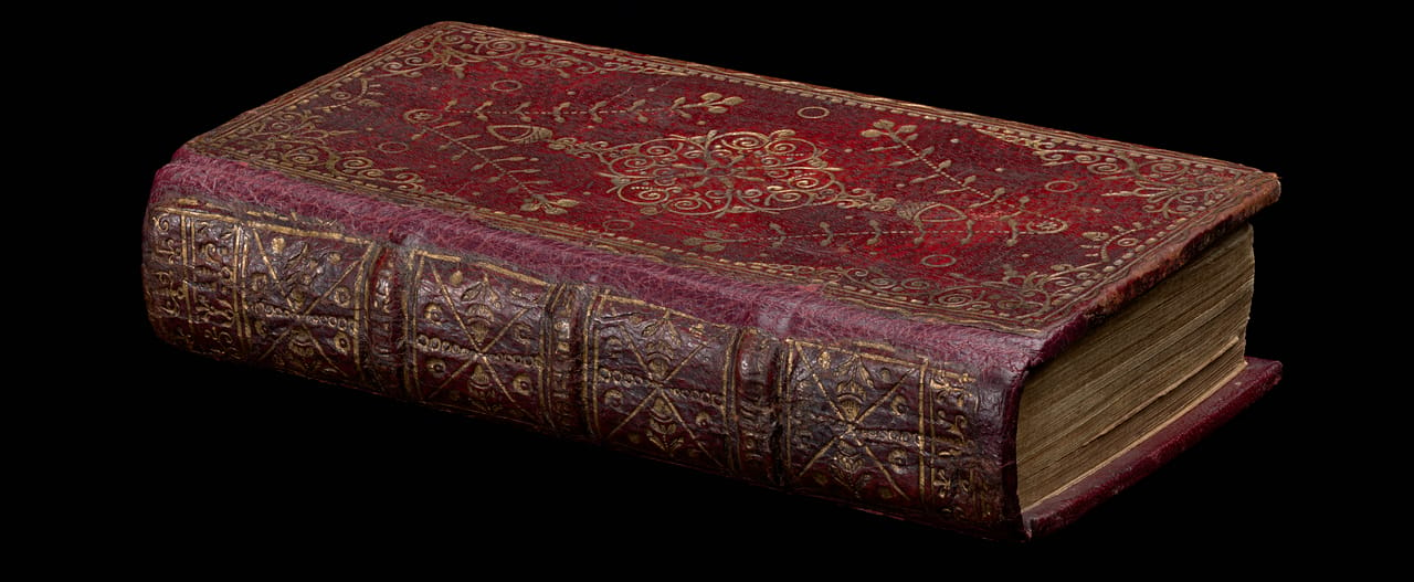 A book bound in red leather with ornate gold embossing. Eikōn basilikē: the pourtraicture of His Sacred Majestie in his solitudes and sufferings, Reprinted in regis memoriam [by William Bentley] for John Williams, 1649. SLV Emmerson Collection RAREEMM 115/29